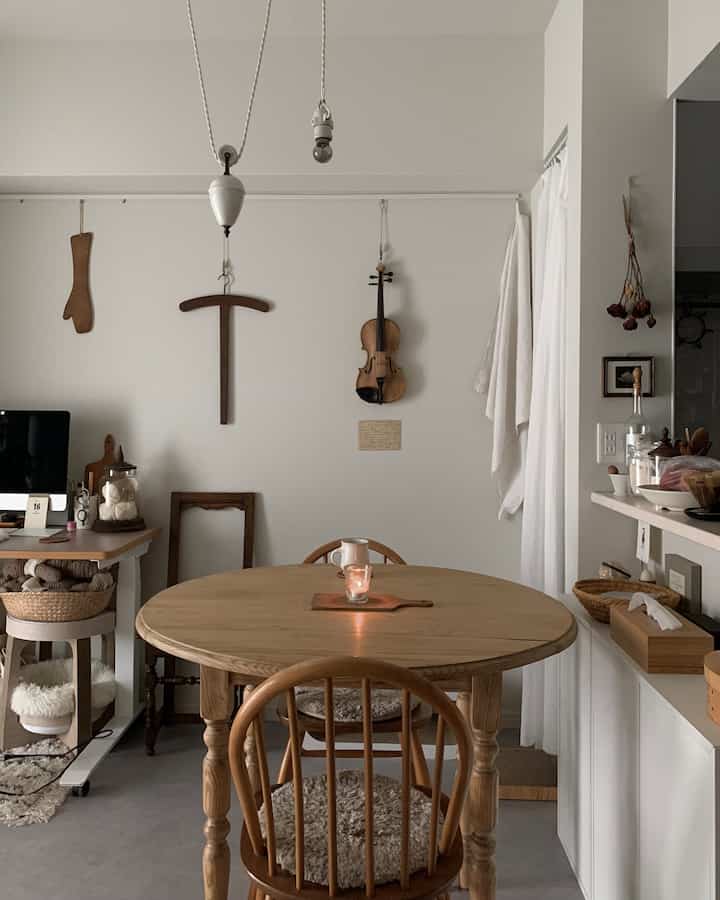 Natural wood tone and white 1LDK dining room featuring wooden dining table and Arco chairs in a cozy antique style space
