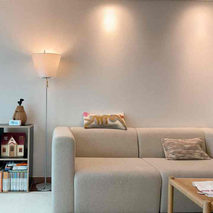 Beige-toned living room featuring a simple sofa and floor lamp with a natural ambiance