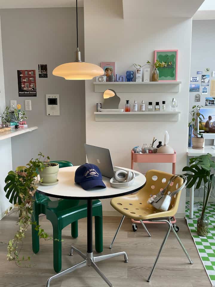 白と緑の色調のダイニングルーム、丸テーブルとダイニングチェア、ペンダントライトが配置された雰囲気のあるおうちカフェ空間