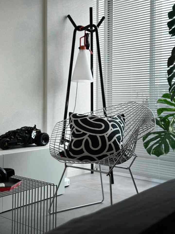 シルバーと黒のトーンのダイニングルーム、メタルワイヤー椅子と黒いクッションが配置された洗練されたモダンなインテリア空間