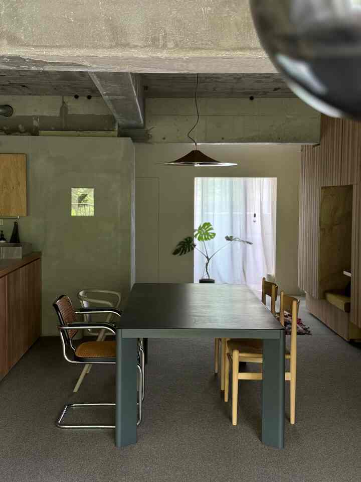 Natural-toned dining room featuring a central dining table with varied chairs in a modern space