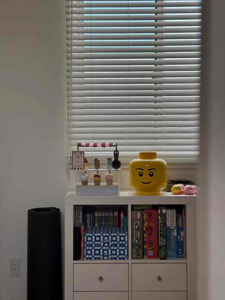 白と黄色のトーンの子供部屋、玩具収納が配置された整然とした印象的な空間