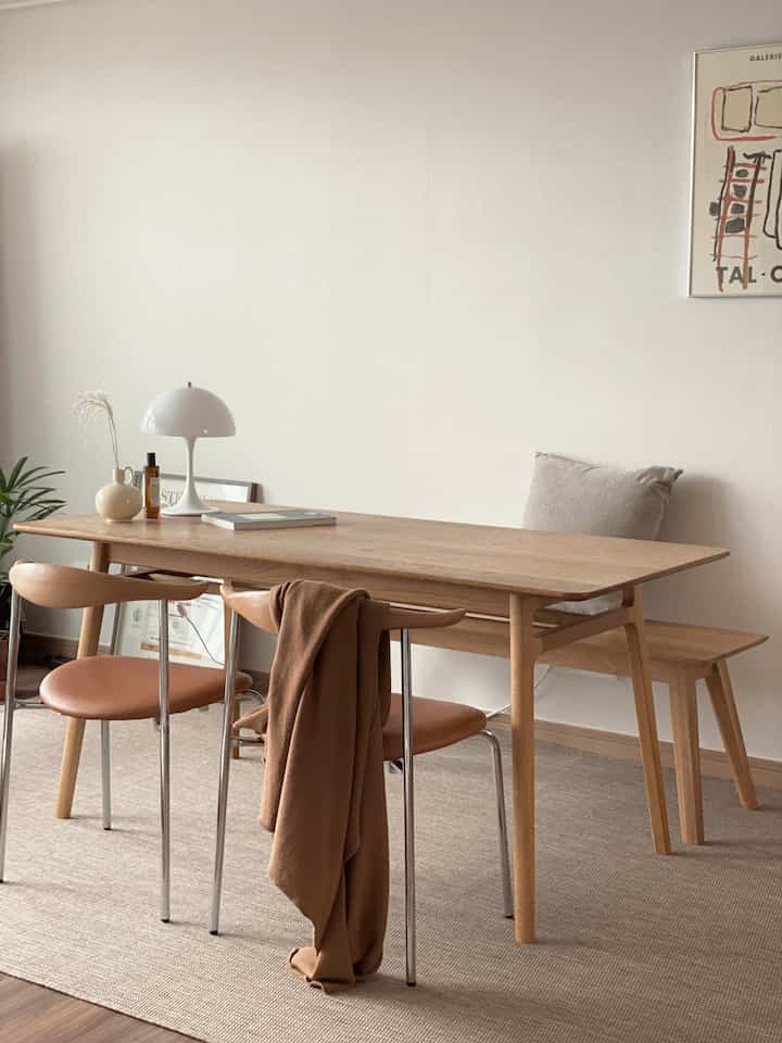 Brown wood-toned dining room featuring mid-century modern table and chairs with warm, natural ambiance