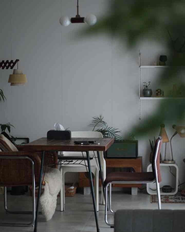 ナチュラルトーンのダイニング、木製のダイニングテーブルと様々な椅子が配置された雰囲気のある空間