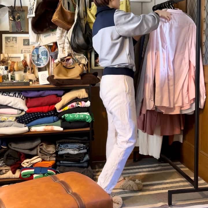 ナチュラルトーンの狭い部屋、コーナー収納棚と衣類掛けが配置された整った空間