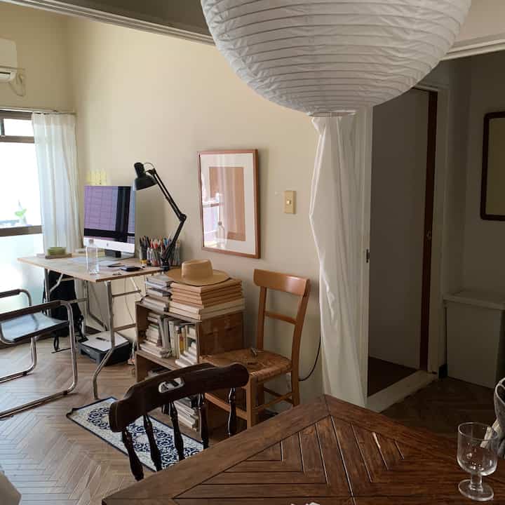 ベージュの壁と木目調家具が配された、ナチュラルモダンなダイニングルーム風ホームオフィス、コンピューターが置かれた空間