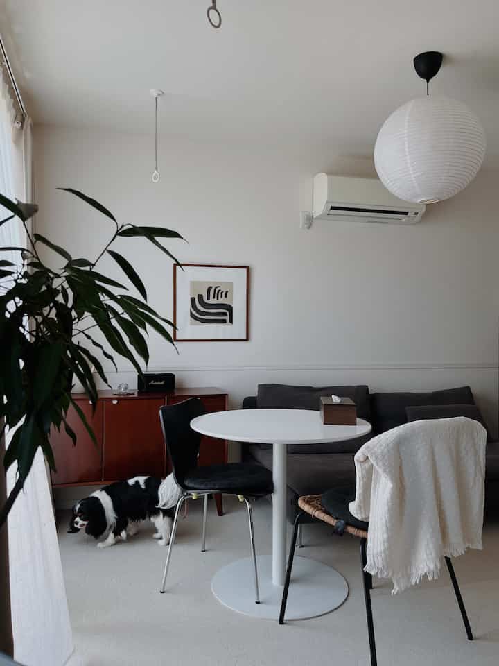 White and brown toned living room featuring Nordic style sofa and dining table with calm, clean atmosphere