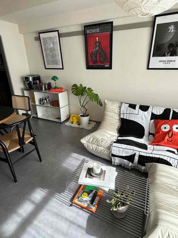Bright white and black living room featuring rattan chairs and plants with a natural modern vibe