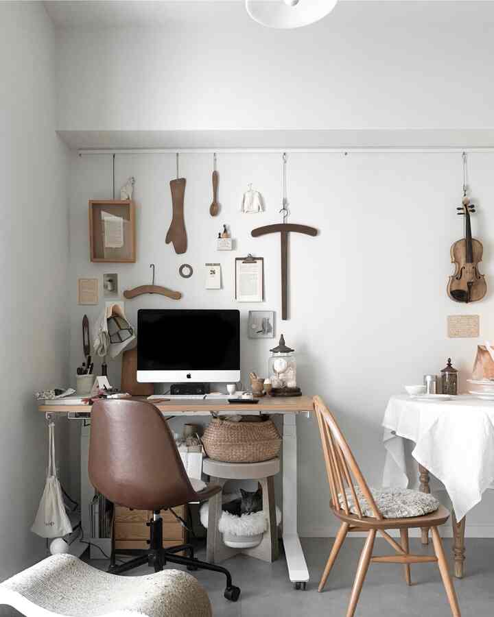 Natural color tone workspace and dining area with desk, chairs, and wall decorations creating a cozy interior