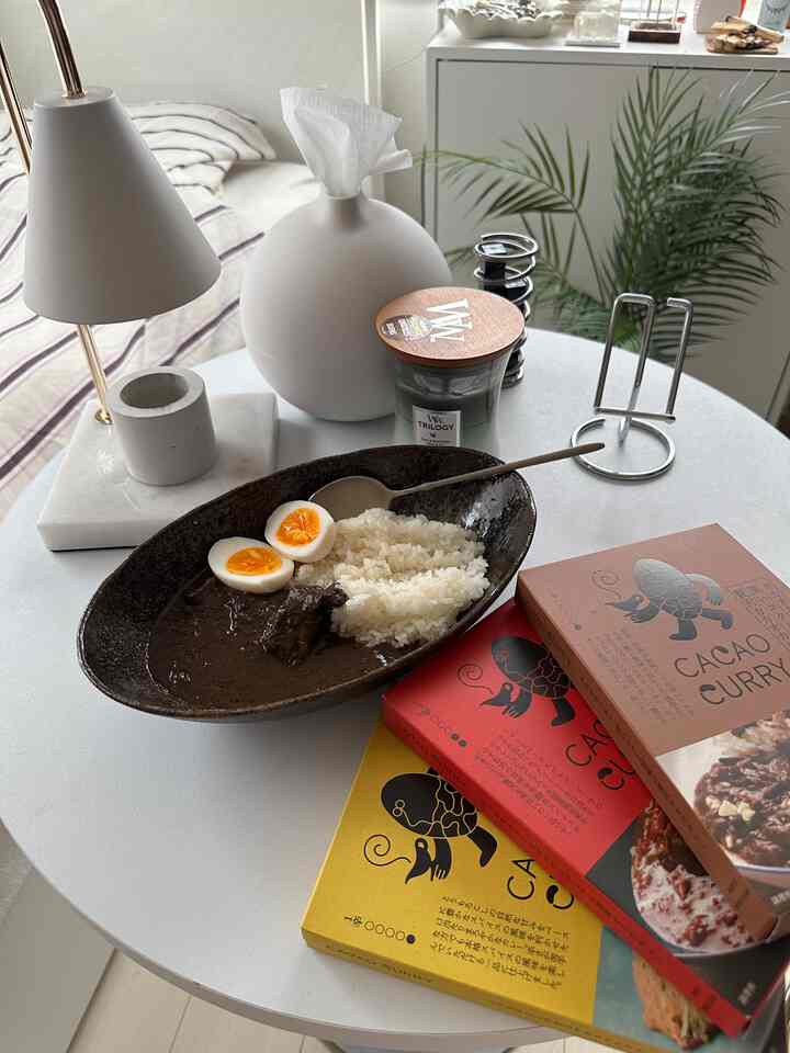 White and natural tone kitchen dining table space featuring meal and candle with cozy atmosphere