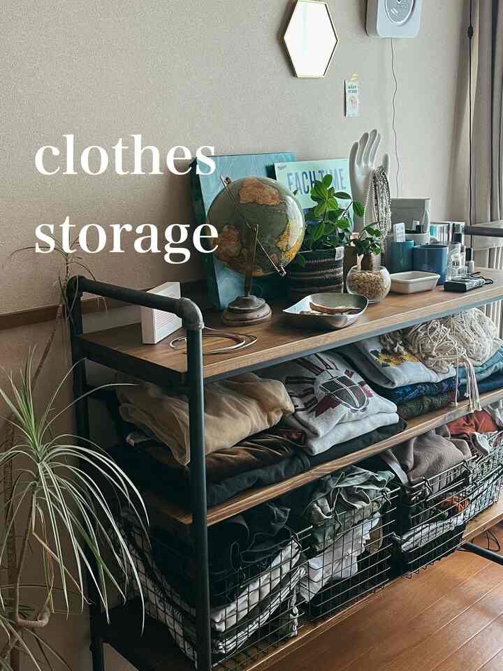 ナチュラルな木目調とベージュの壁が調和したクローゼット棚、畳まれた服とワイヤーバスケットが整然と配置された収納スペース