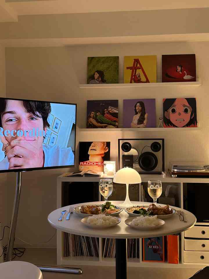 白を基調とした居心地の良いリビングダイニング、二人分の食事セットとテレビ台、モダンなインテリアが調和した空間