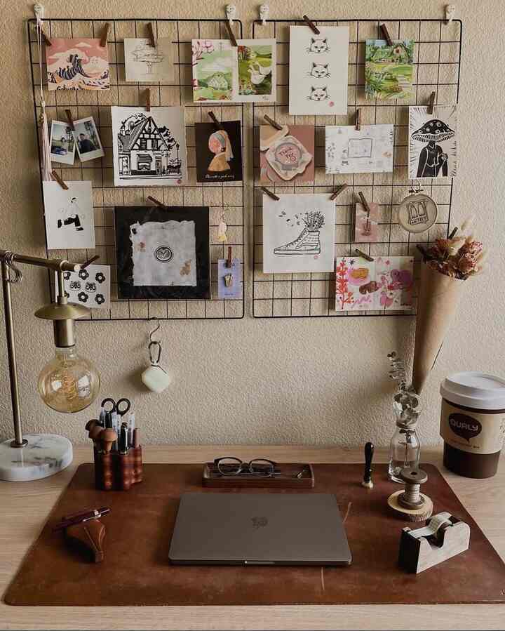 Natural modern home office with brown leather desk mat, metal wire memo board displaying photos and artwork