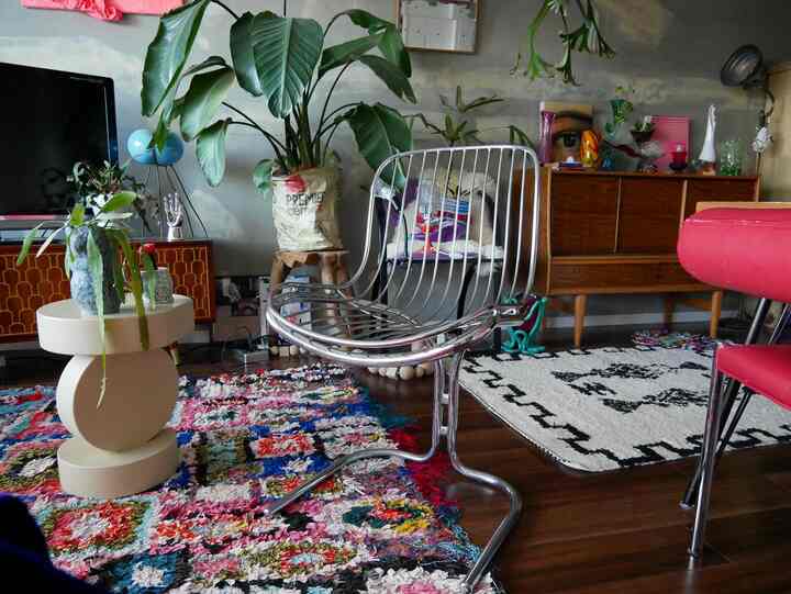 木目調のナチュラルモダンなリビング、メタリックなスツールと多様な植物が配置された印象的な空間