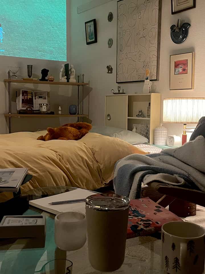 Mustard yellow bedding bedroom with a projector screen, cozy natural modern style furnishings arranged