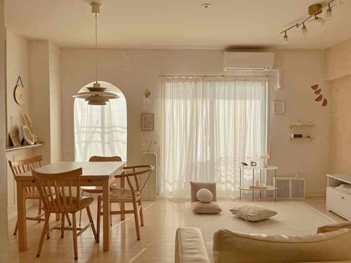 アイボリーと木目調の温かみあるリビング、木製ダイニングテーブルと柔らかなカーテンが印象的な空間
