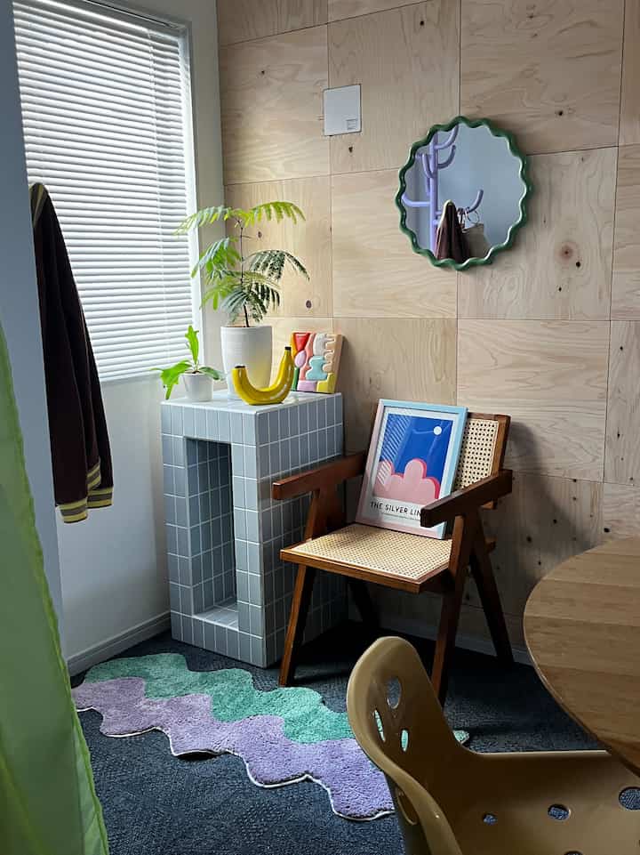 Natural wood tone wall with rattan chair and green plants in a cozy living room setting