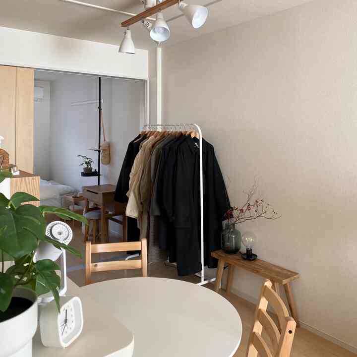 Natural style living room in white and beige tones, featuring dining table, bench, and plants in a cozy atmosphere