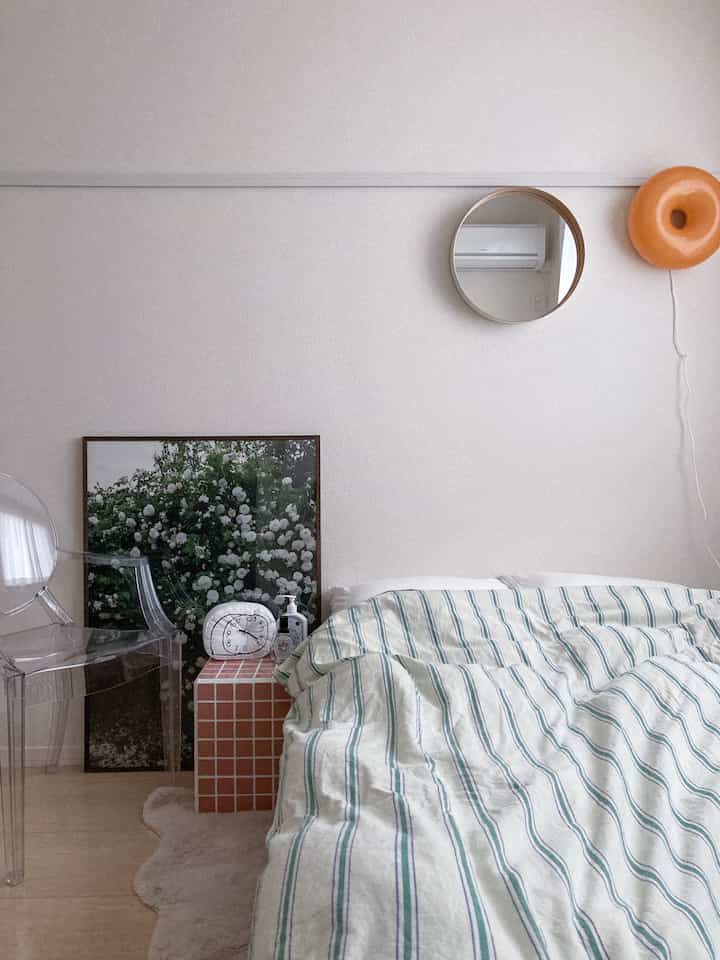 白とブラウンのトーンの寝室、タイルテーブルとポスターが配置されたミッドセンチュリーモダンな印象的な空間