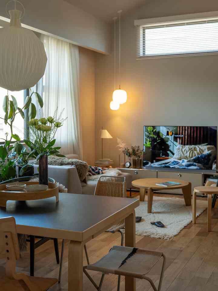 A white and wood tone living room featuring round coffee table and stools with a natural modern atmosphere