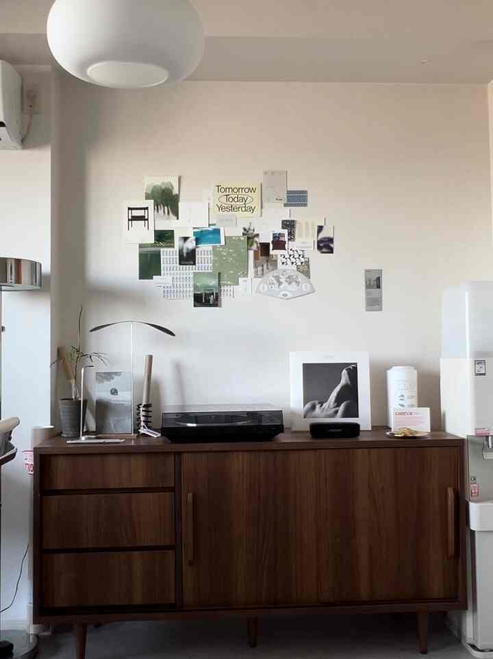 ナチュラルカラーとブルーアクセントのリビング、木製のテレビ台にオブジェとターンテーブルが配置され、明るく落ち着いた雰囲気のインテリア