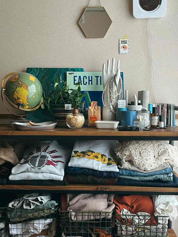 ブラウン色調の収納棚がある空間、整頓された服とオブジェが配置された温かみのあるインテリア