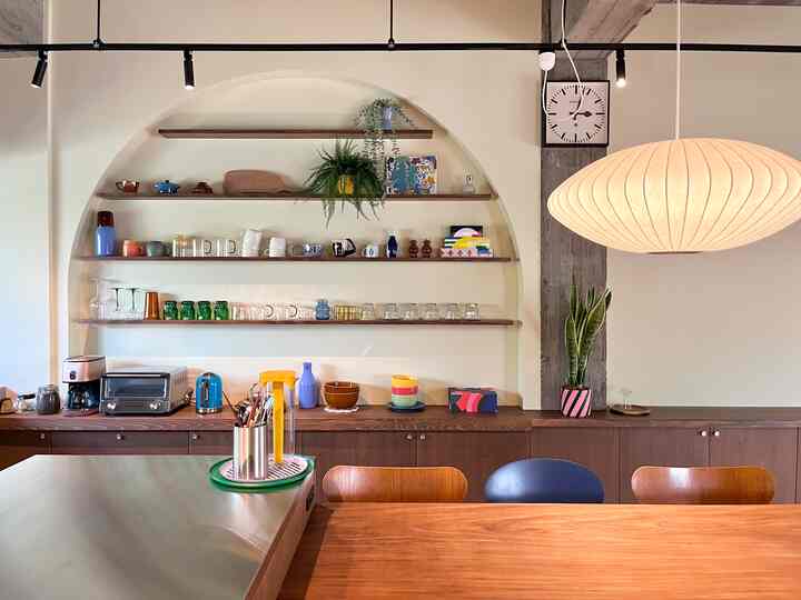 明るいベージュ色調の壁とミッドセンチュリーモダンのダイニングテーブル・チェアが配置された広々とした清潔感のあるダイニングルーム