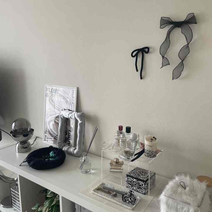 明るいホワイトトーンのリビング、チェストと整然としたディスプレイ小物が配置されたミニマルなインテリア