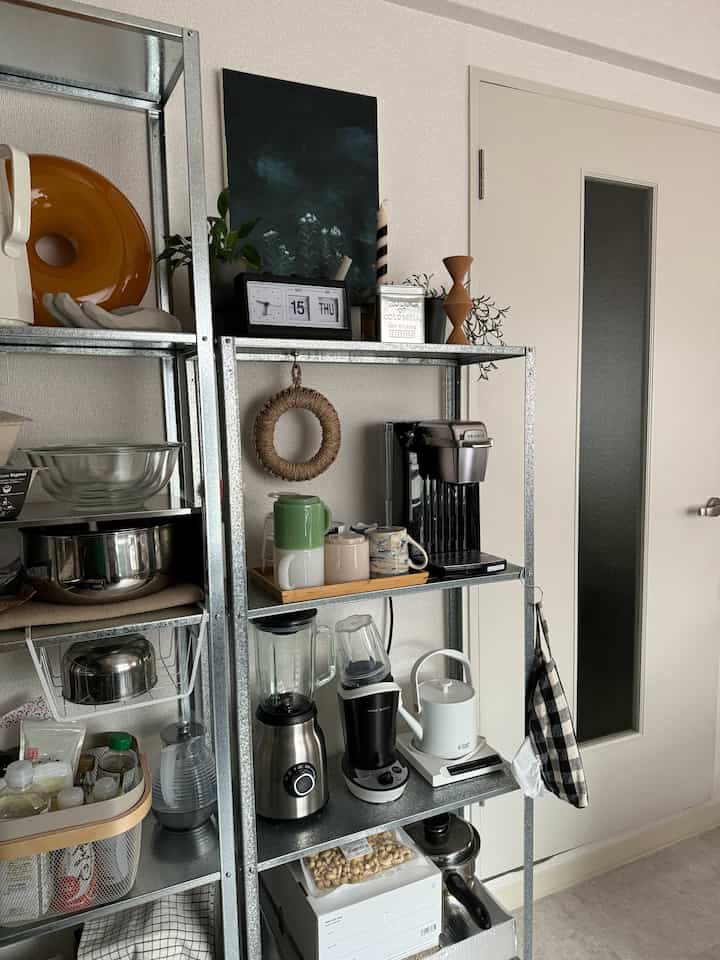 Natural tones and metal materials in a single household kitchen featuring practical storage shelves and kitchen appliances in a simple setup