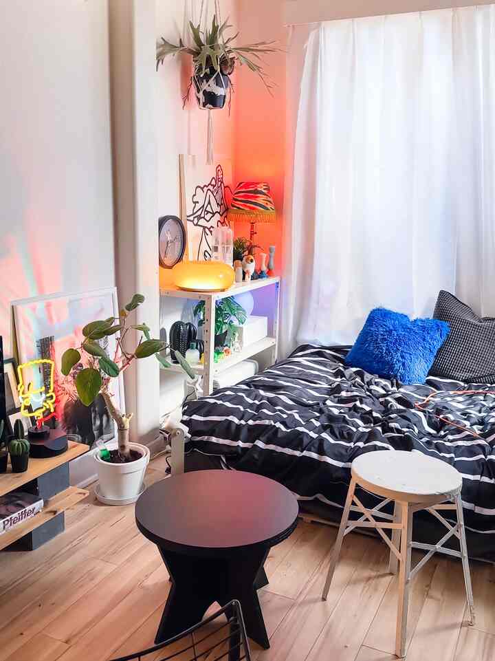 Bright and cozy 6-tatami studio bedroom with white walls and curtains, black and white bedding, featuring diverse lighting and interior accessories