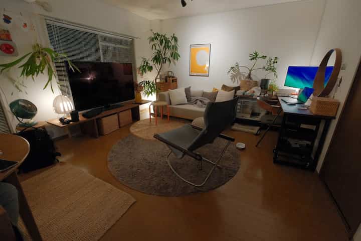 Natural color and light brown toned living room featuring sofa, armchair, and desk with computer, creating a cozy space