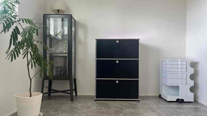 Simple modern kids' room with white walls and floor, featuring black USM cabinet and white Boby Wagon for neat storage