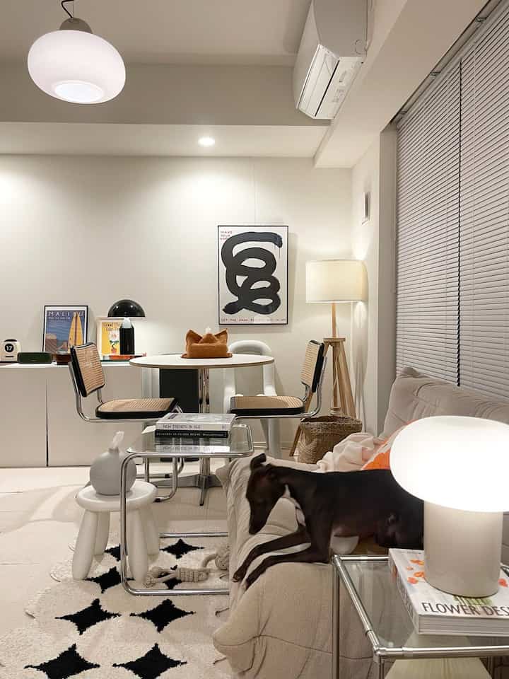 White and brown toned living and dining area featuring a dog resting on the sofa with a cozy modern atmosphere