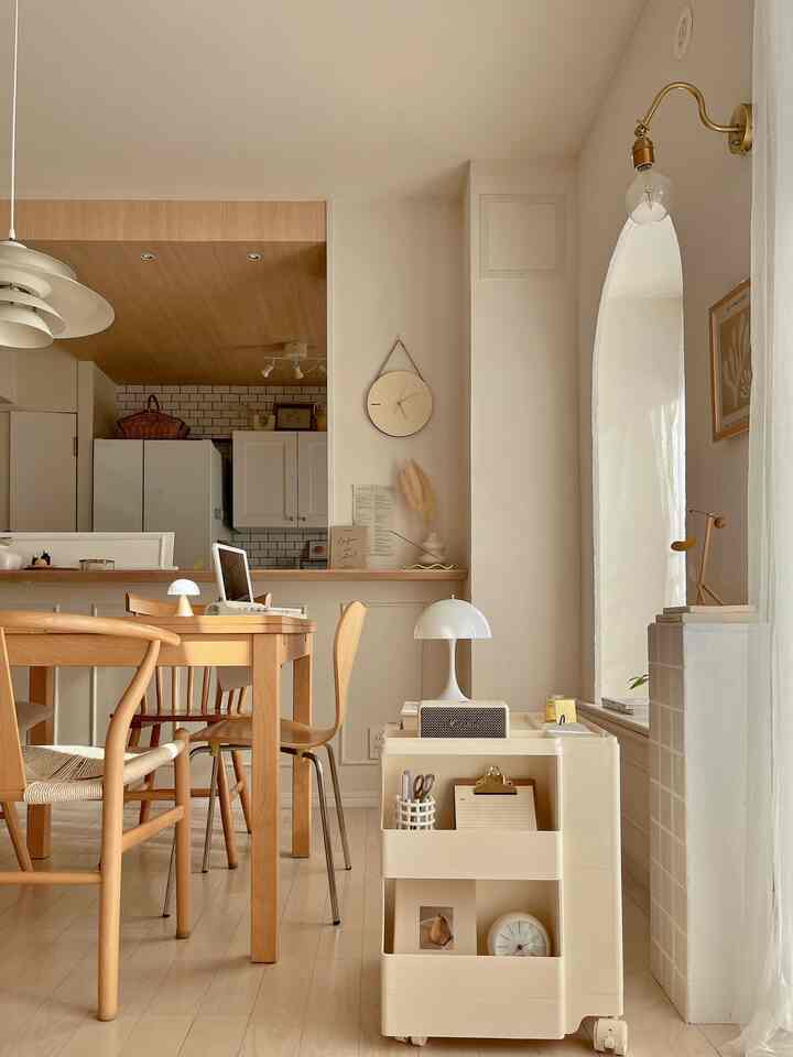 アイボリーの収納キャリーと木目調のダイニングテーブルが配置されたナチュラルなキッチン・ダイニングルームのインテリア