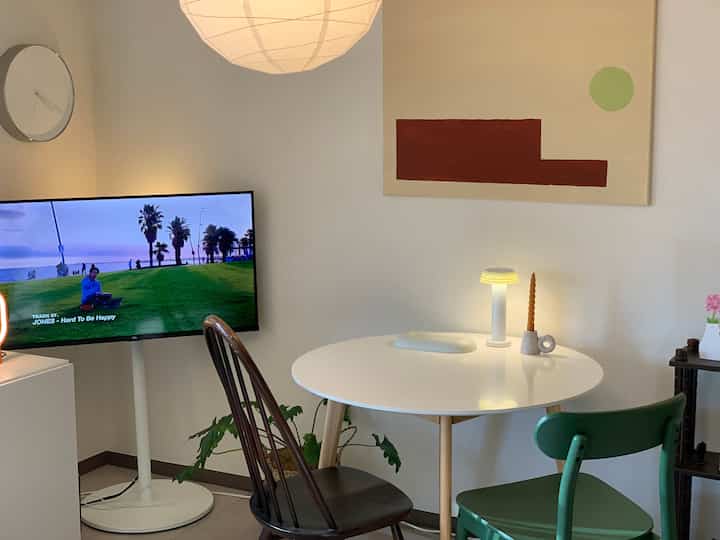 White and beige toned dining room featuring a round dining table and mixed chairs in a cozy setting