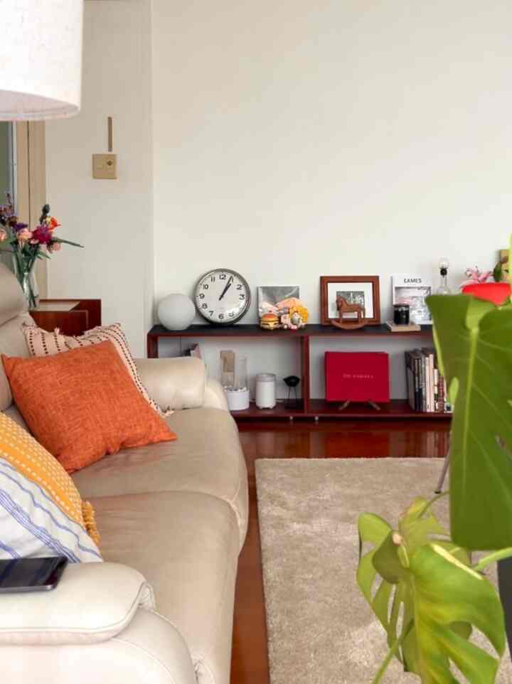 ナチュラルカラーのリビング、白いソファとベージュのラグが置かれた雰囲気のある空間