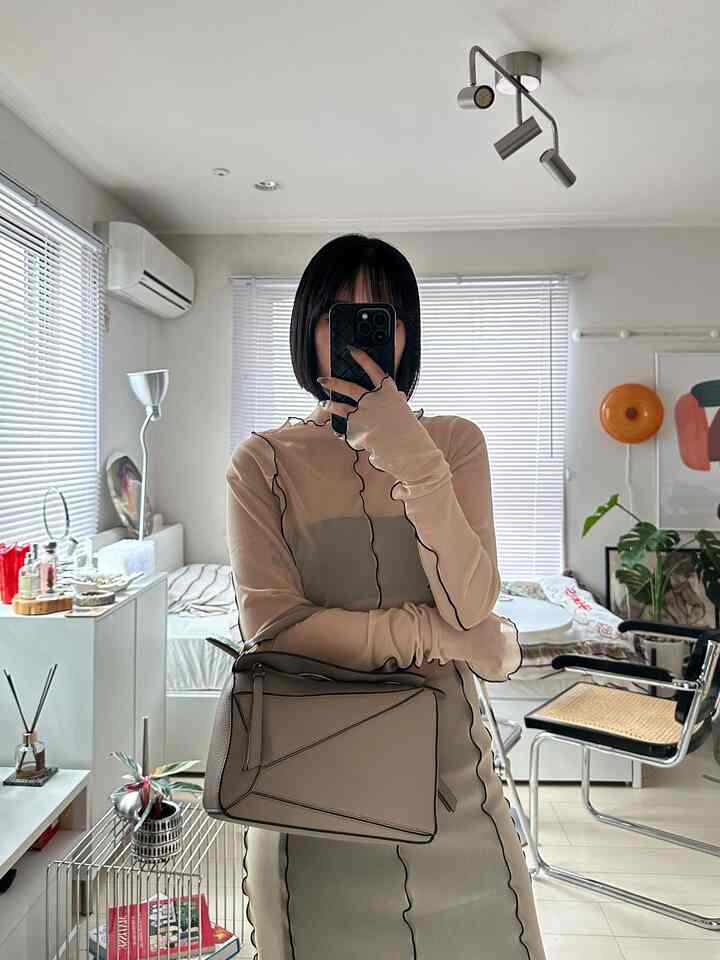 White-tone living room featuring a large mirror and silver lighting with a modern interior style