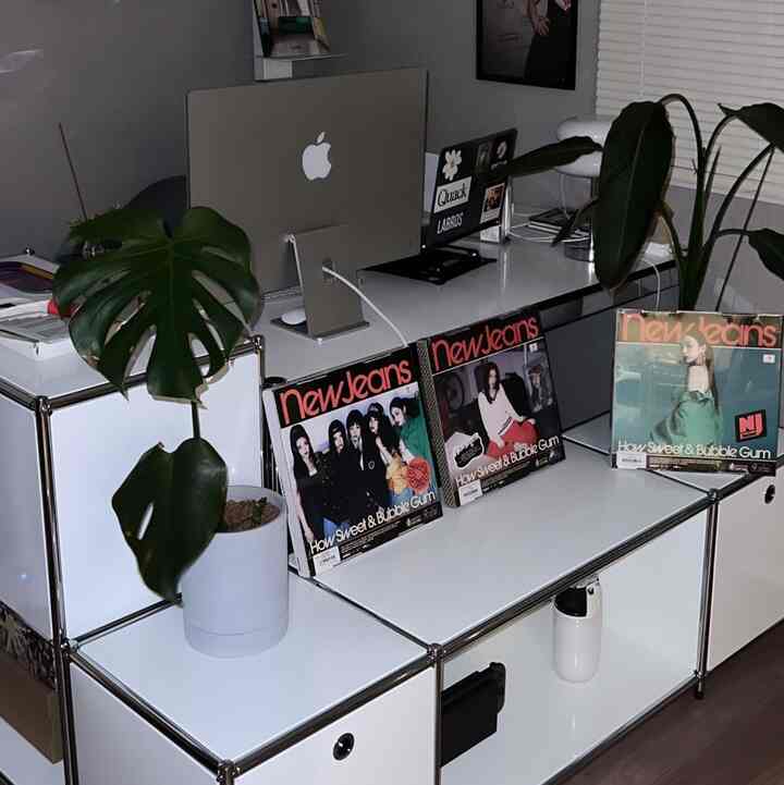 白を基調としたシンプルなホームオフィス空間、モジュラー収納と植物が配置された清潔感のあるインテリア