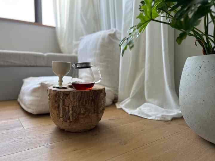 木目調の床と白いクッション、木製のローテーブルと植物が配置されたナチュラルなホームカフェ空間