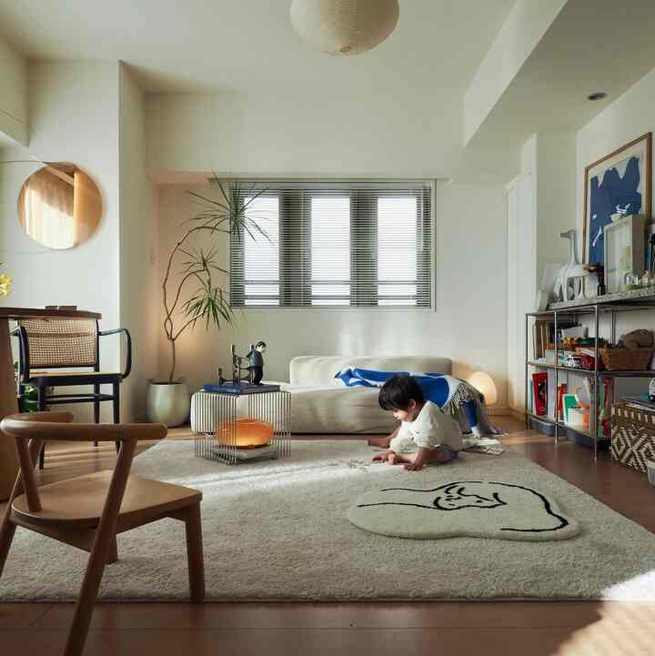 Natural wood tone and white 6-tatami living room featuring a child sitting on a rug in a simple, cozy space