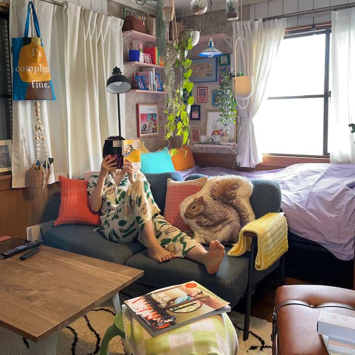 Lavender bed and colorful cushions in a living room with framed pictures and plants creating a cozy atmosphere