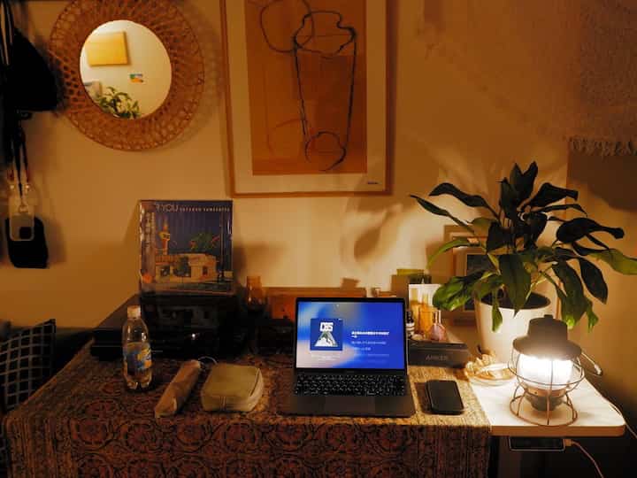 暖かいブラウンの色調のワンルーム6畳、デスクと植物が配置された雰囲気のあるおうちカフェ空間