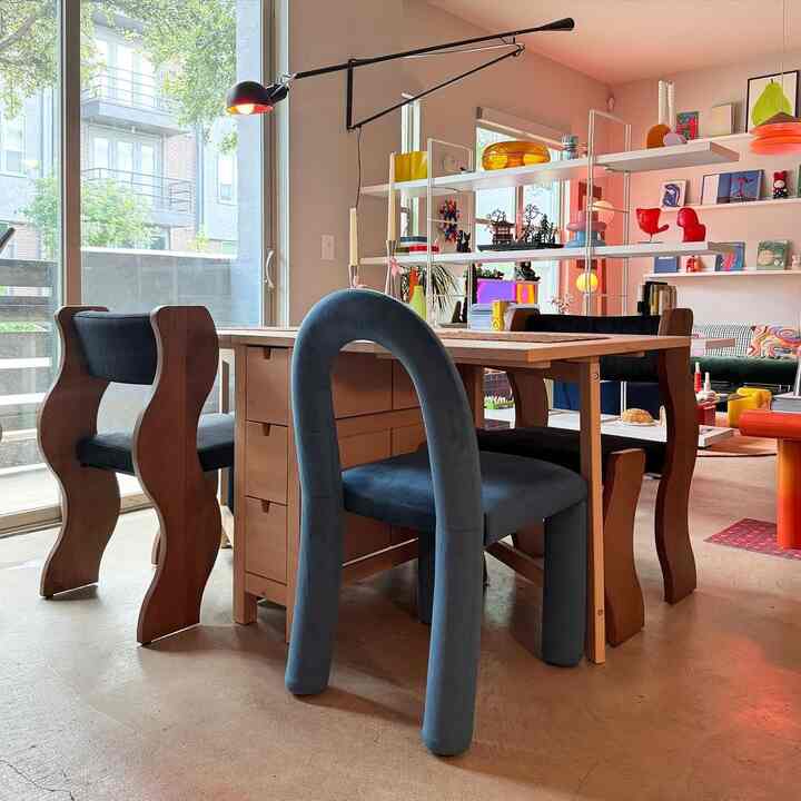 Natural-toned dining room featuring uniquely designed dining chairs and wall lighting in a modern setting