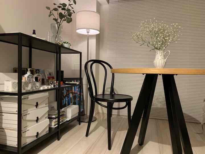 A modern single household dining space with white walls and flooring contrasted by black furniture