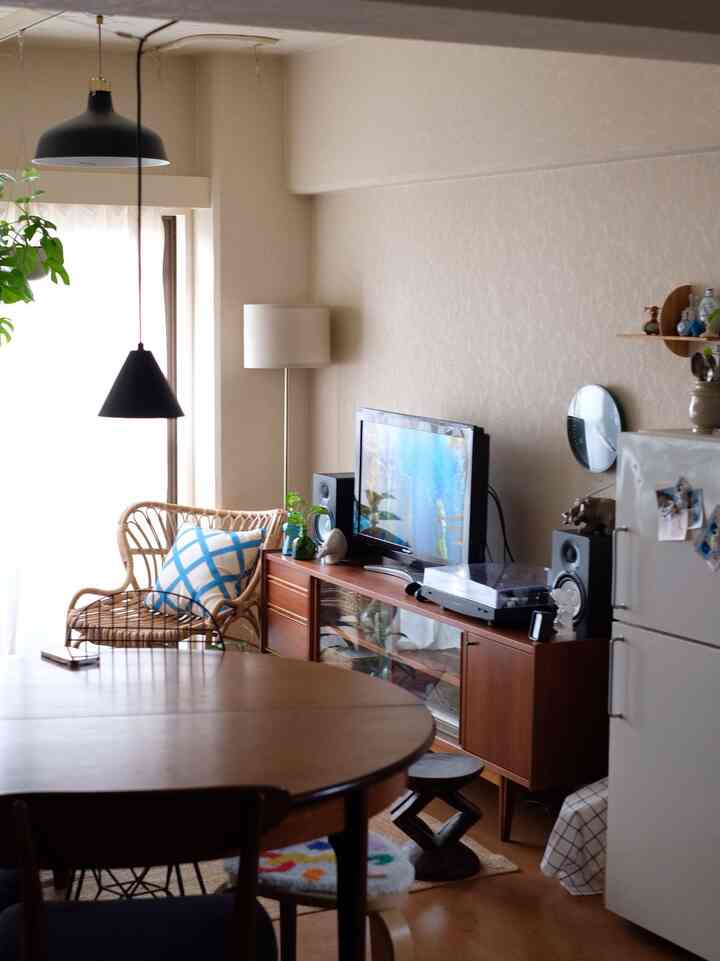 ブラウンの木目調家具と白いカーテンが調和したワンルームのリビング、ナチュラルな雰囲気のインテリア