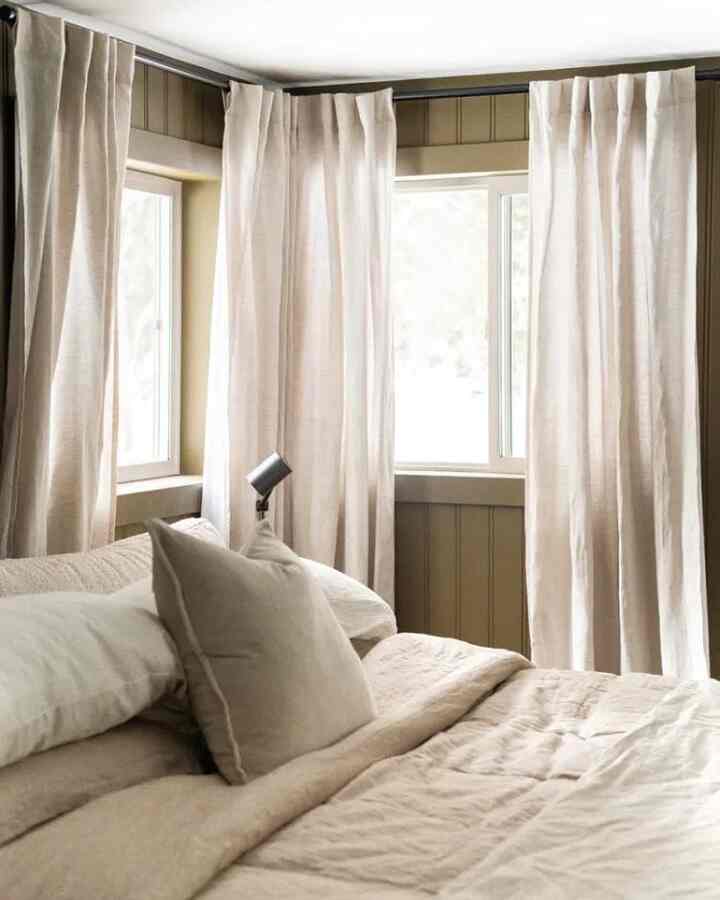 Beige-toned bedroom with pillows, bedding, and curtains arranged in a cozy and natural atmosphere