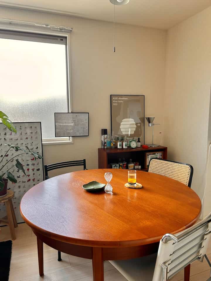 木目調のナチュラルなダイニングルーム、丸いテーブルとダイニングチェアが配置された雰囲気のある空間