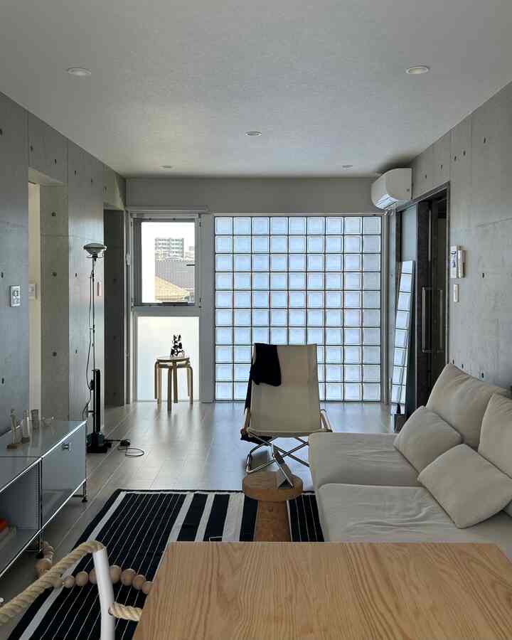 白とナチュラル色調のリビング、サイドテーブルとラグが配されたシンプルでモダンな雰囲気のインテリア