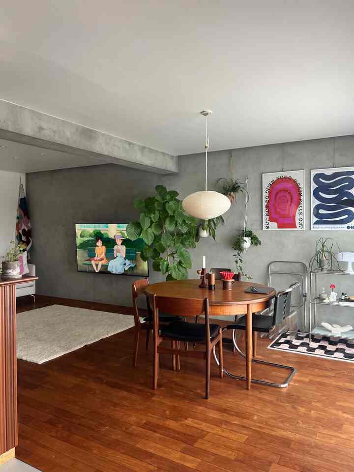 Mid-Century Modern dining and living room with natural brown wood flooring and gray concrete walls