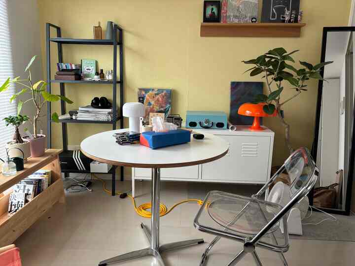 黄色い壁に白い家具が配置された一人暮らし用のホームオフィス、シンプルでナチュラルな雰囲気のあるインテリア